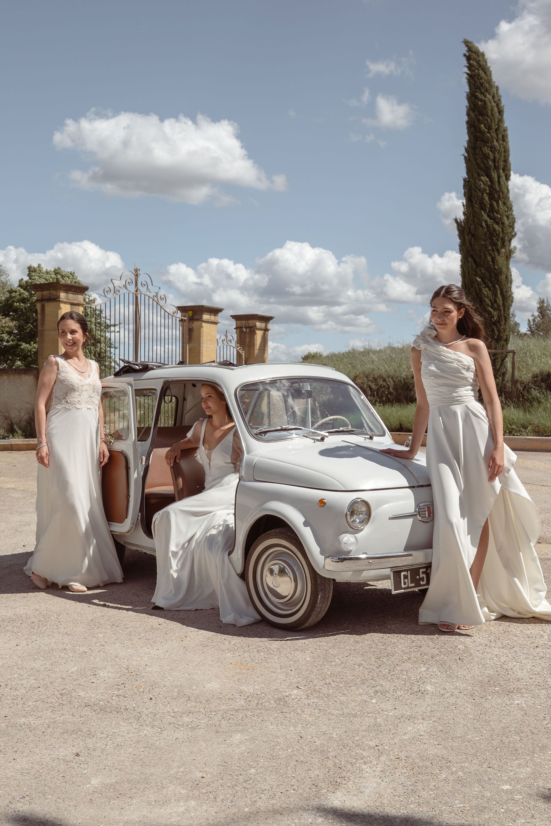 Mariées posant devant la Fiat 500 vintage aux portes du domaine