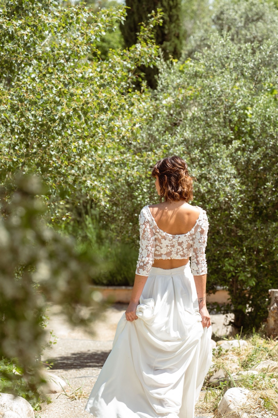 Mariée de dos dans les jardins verdoyants du domaine