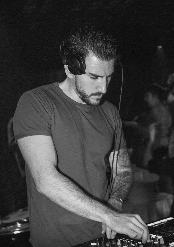 DJ aux platines pendant une soirée, casque sur les oreilles — photo en noir et blanc