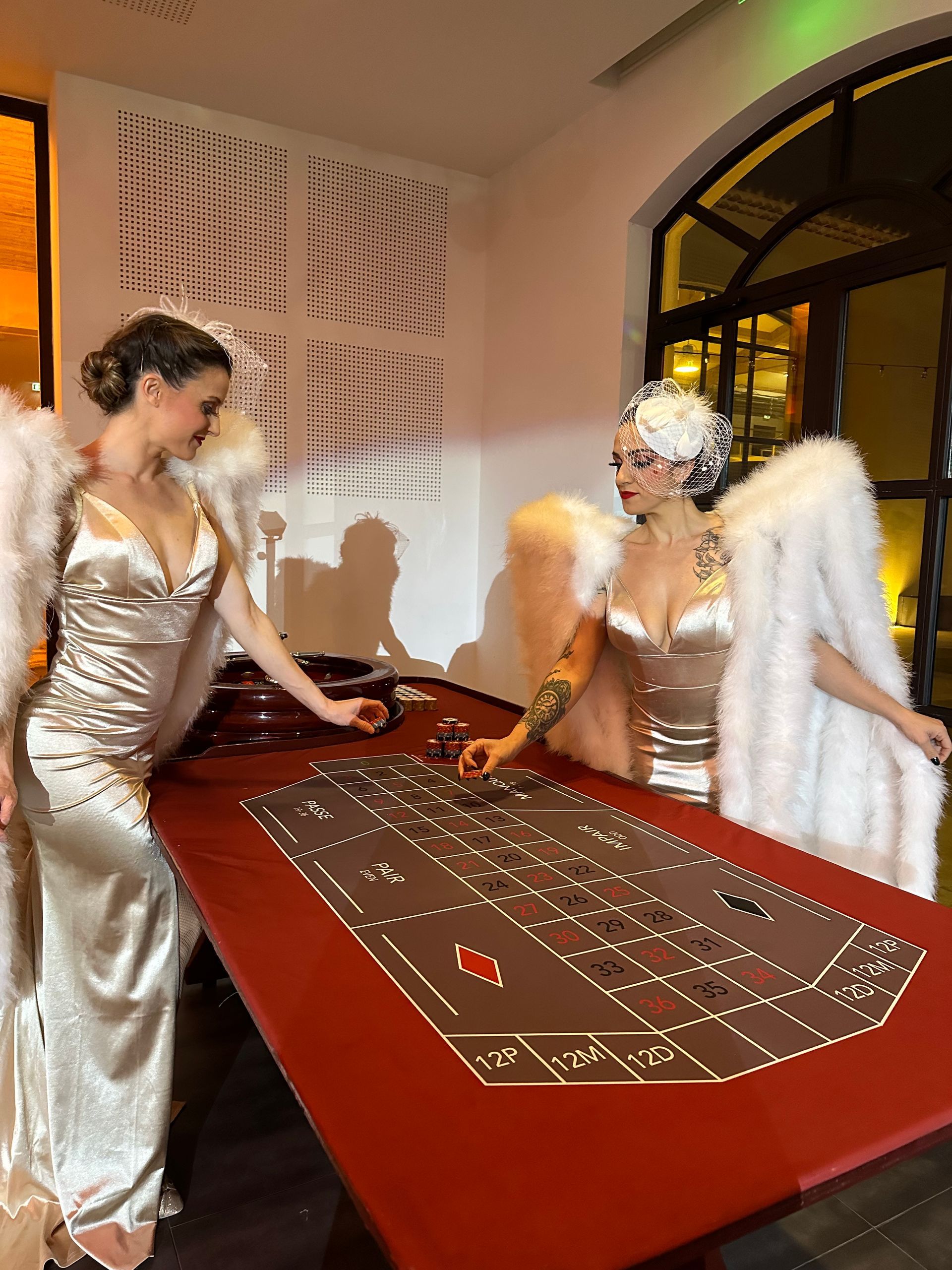 Invitées en tenue de soirée autour d’une table de roulette lors d’une soirée de gala